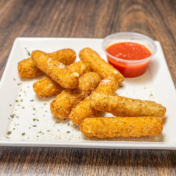 A white rectangular plate filled with golden-brown mozzarella sticks, sprinkled with herbs and parmesan, with a side of marinara sauce.