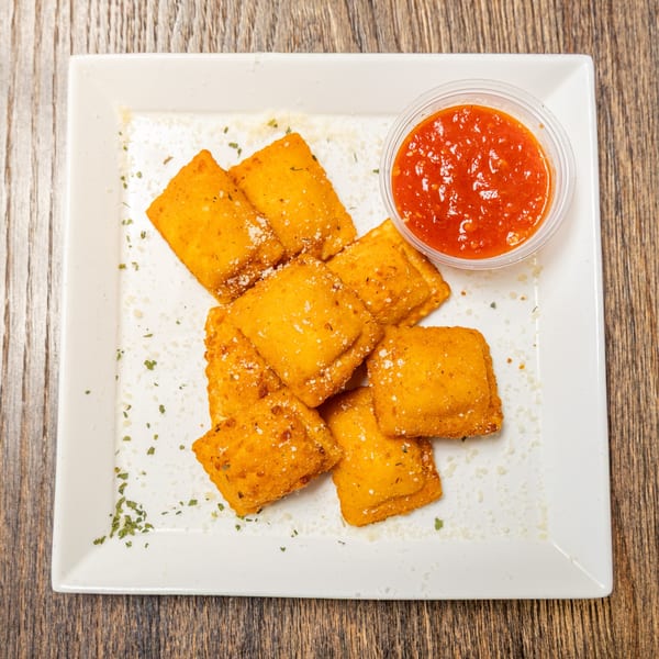 Golden-brown fried ravioli sprinkled with parmesan cheese and herbs, served with a side of marinara sauce.